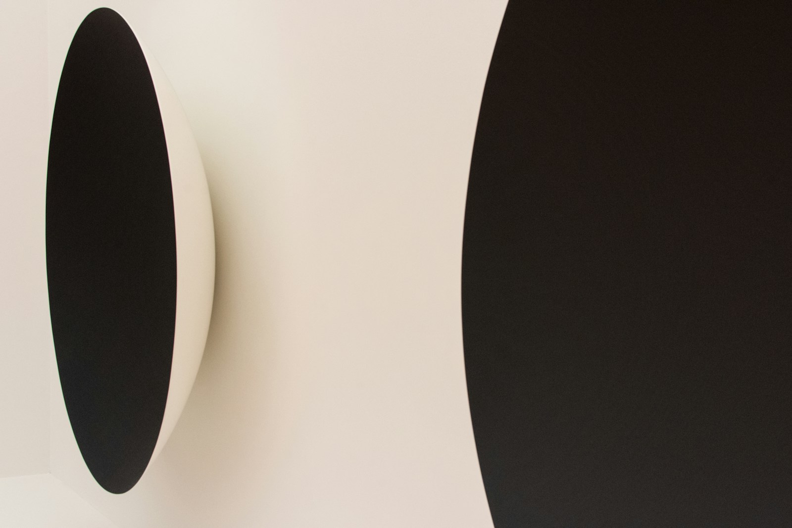 a black and white wall mounted speaker next to a white wall
